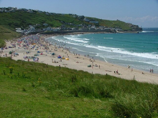 A coastal beach with tents and people.