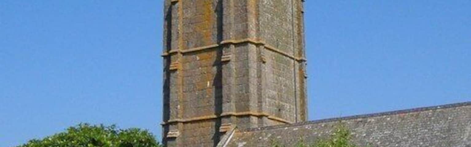 Church of St Buryan "North wall of chancel is C12, otherwise C15 and possibly early C16 ... Largely unaltered late medieval exterior, with most of the original openings ... Tall C15 4-storey embattled tower has buttresses set back from the corners; strings dividing the stages" http://www.imagesofengland.org.uk/details/default.aspx?id=69682 In the foreground is the WW1 war memorial, a "large ogee-headed arched niche containing a pierced wheel-headed cross" http://www.imagesofengland.org.uk/Details/Default.aspx?id=69697&mode=adv . The circular churchyard probably indicates pre-Christian origin, in this case "the enclosure wall of a late Iron Age enclosed settlement".