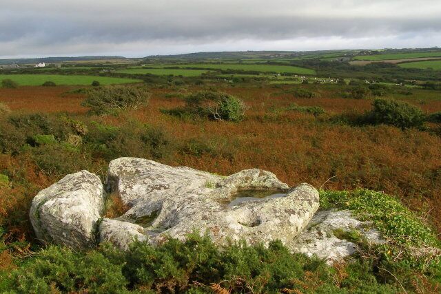 View south-east from Creeg Tol A short distance south of the A30 road, the rocks in the foreground are at Creeg Tol. The Boscawen-un stone circle is at the bottom of the bracken-covered slope. The south coast is just over the horizon - the dip towards the left is at Lamorna.