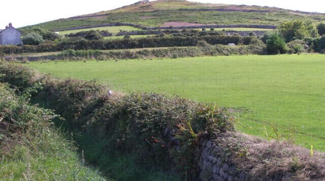 View towards Carn Eanes from Pendeen car park. Carn Eanes looms over Higher Boscaswell. The field in the foreground is Pendeen School's sports pitch.