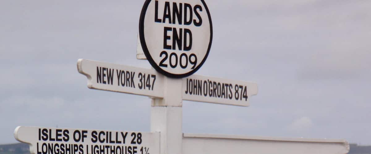 A directional signpost with destinations and dates.
