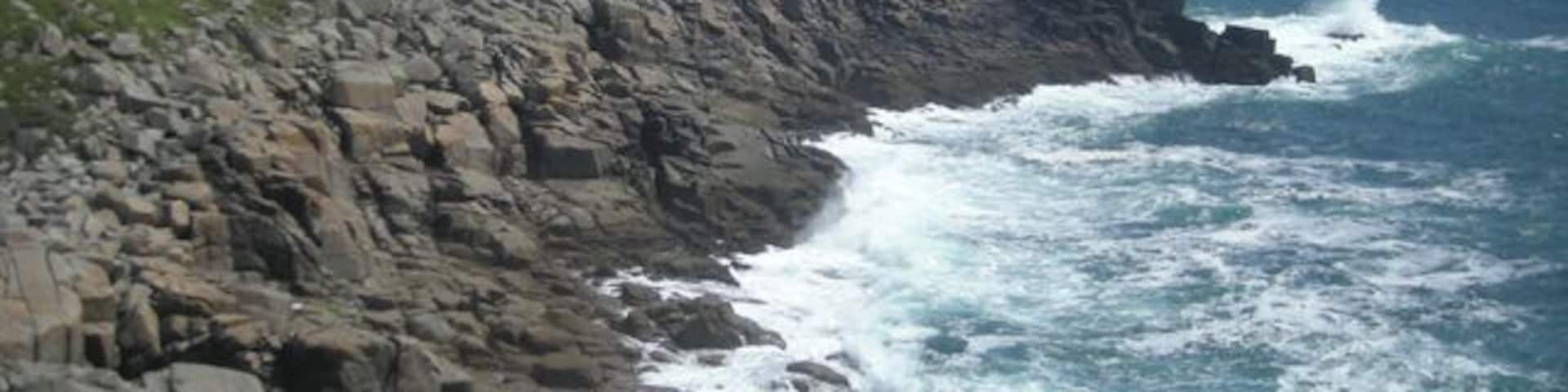 A rocky coastline with waves crashing against the shore.