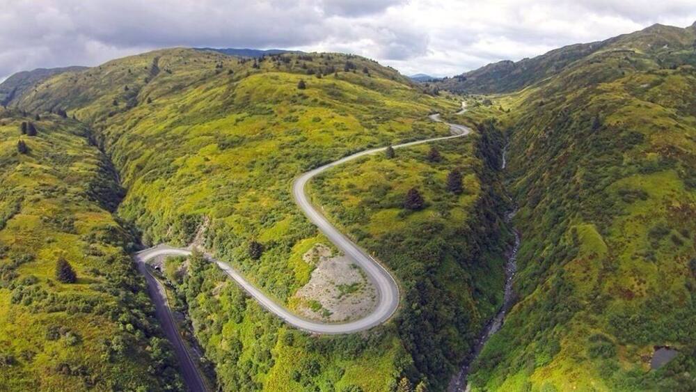 Une route de montagne sinueuse qui traverse de verdoyantes collines.