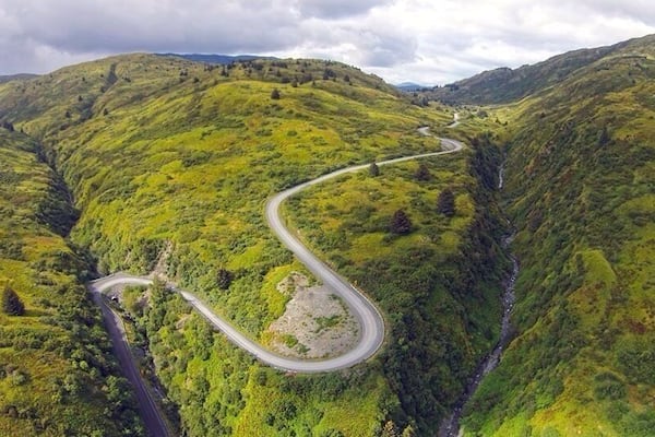 Une route de montagne sinueuse qui traverse de verdoyantes collines.