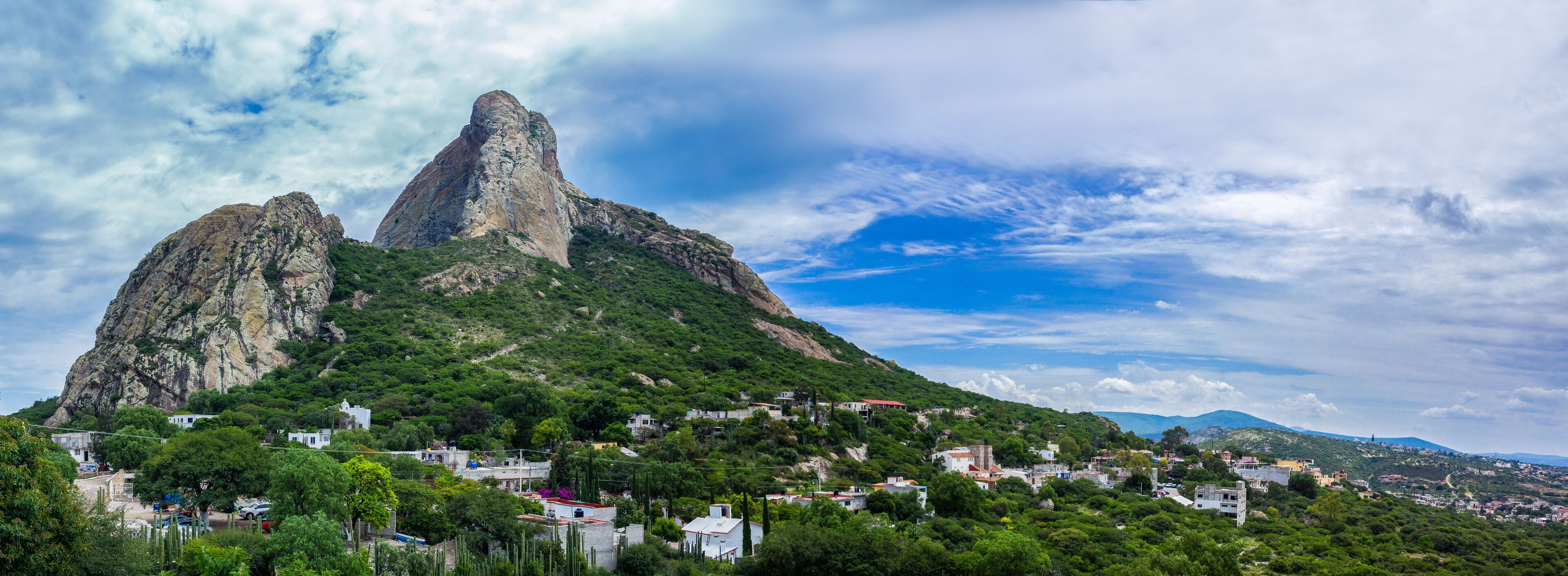 A mountainous landscape with two prominent peaks and a town at the base.
