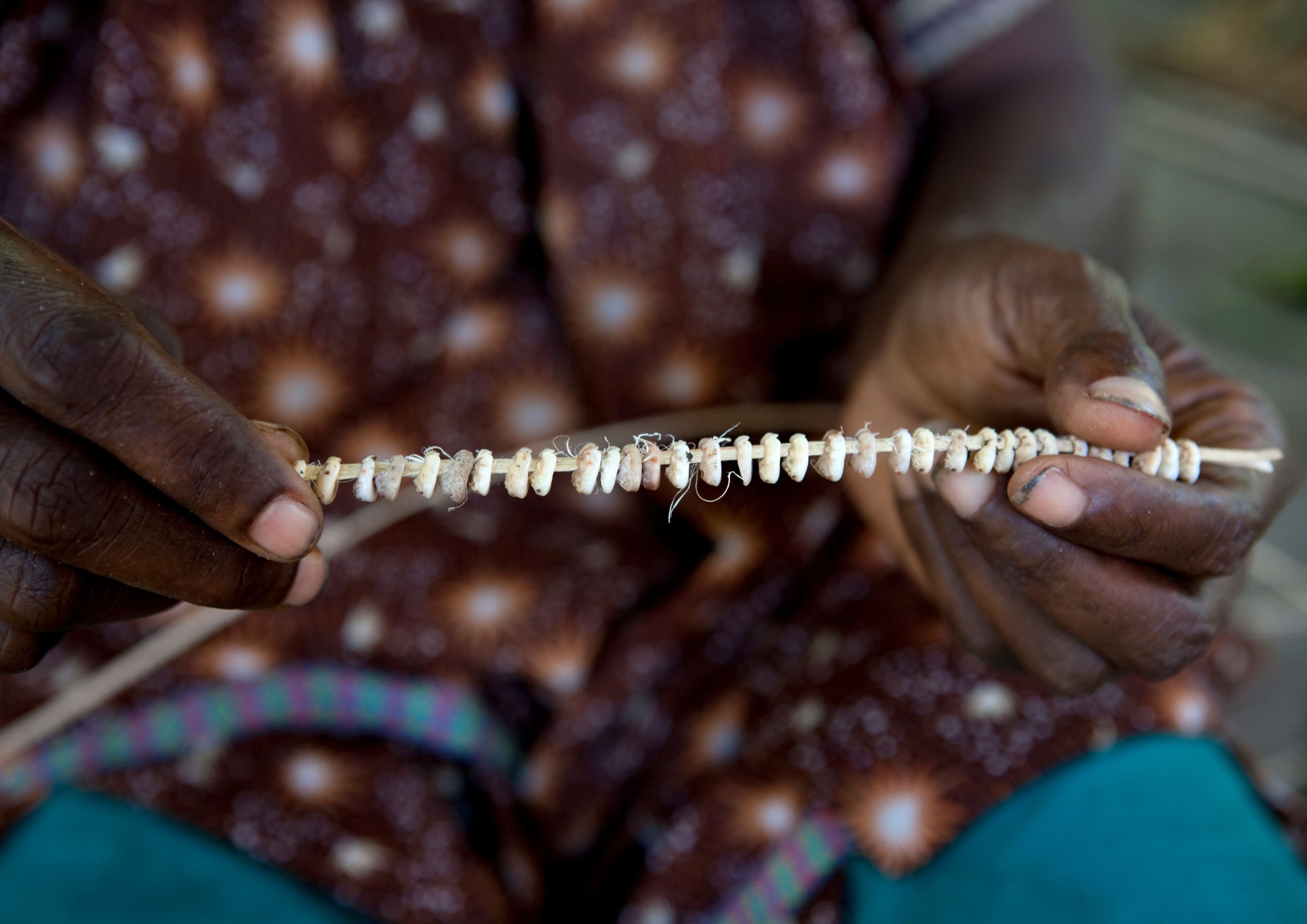 A person holding a string of beads.
