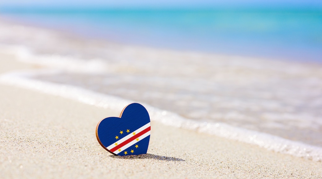 Flag of Cape Verde in the shape of a heart on a sandy beach. The concept of the best vacation in Cape Verde and Africa