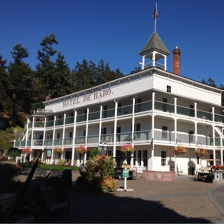 A white building with balconies and a sign that reads "Hotel de Haro."