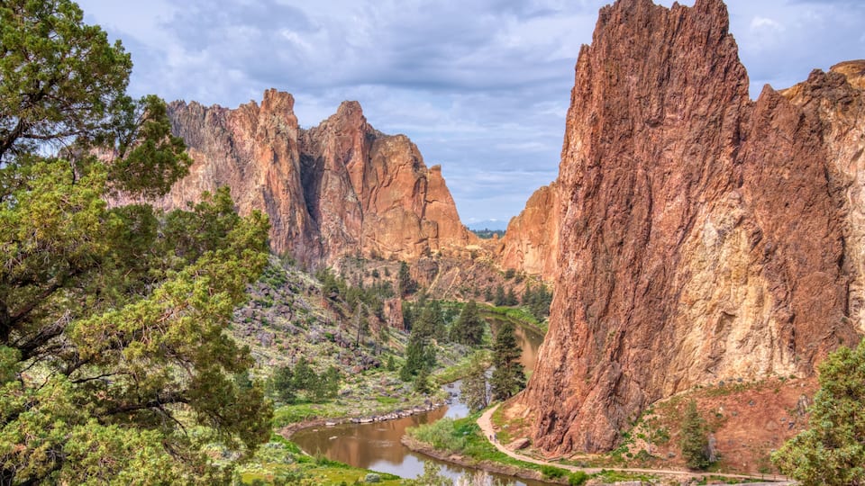 A canyon with a river, rocky cliffs, and trees.
