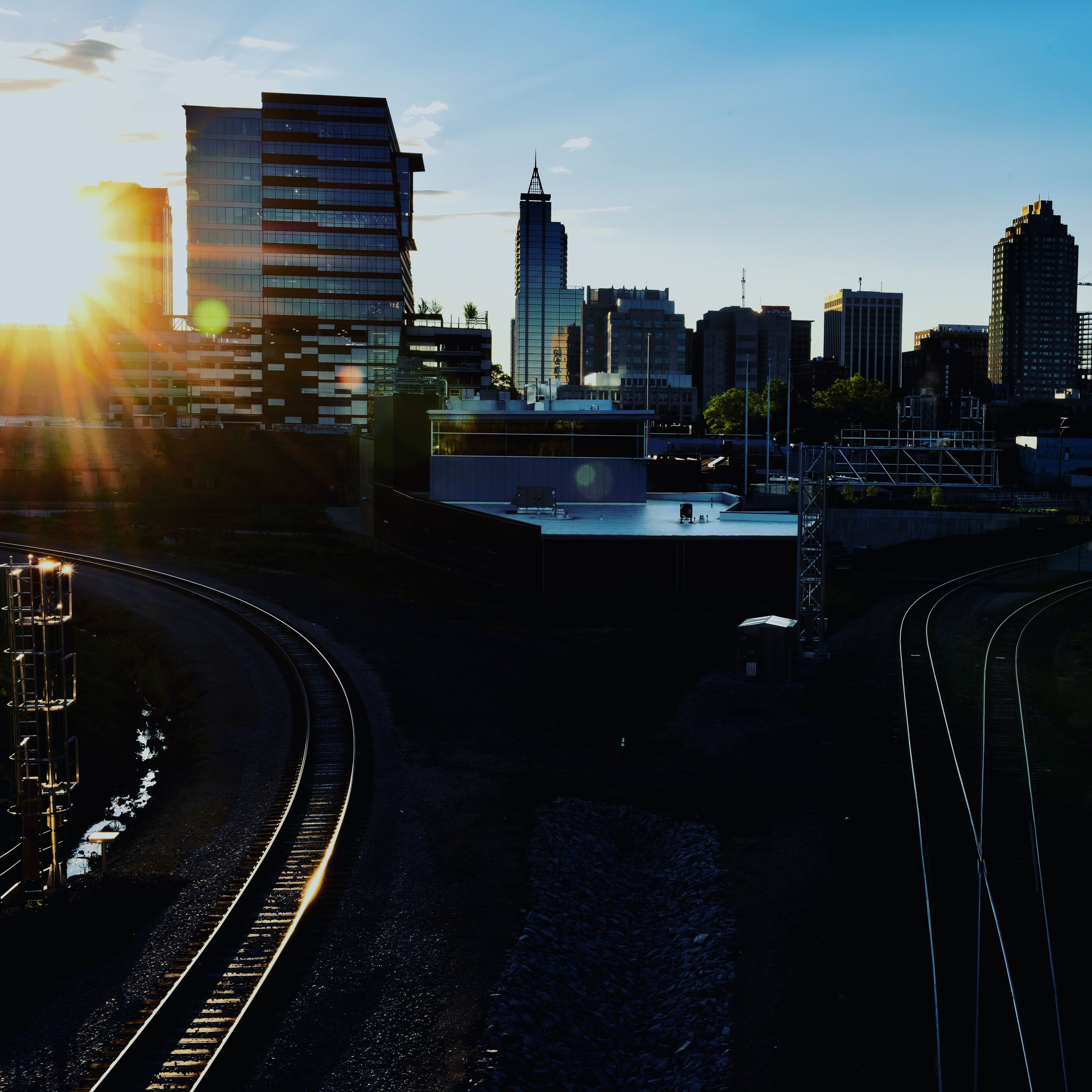 A cityscape with modern buildings and a railway track.
