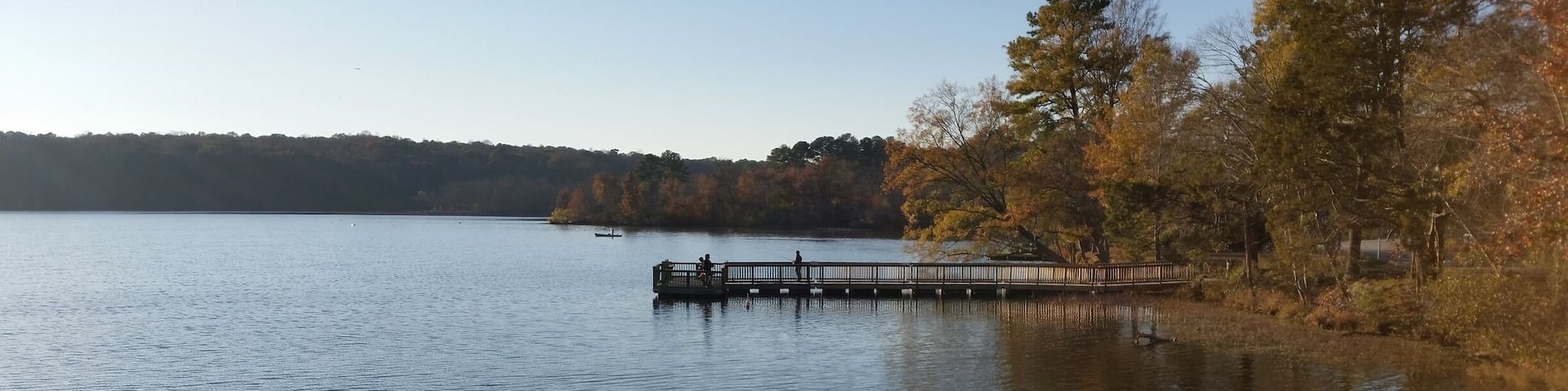 A calm lake with a wooden pier extending into the water.