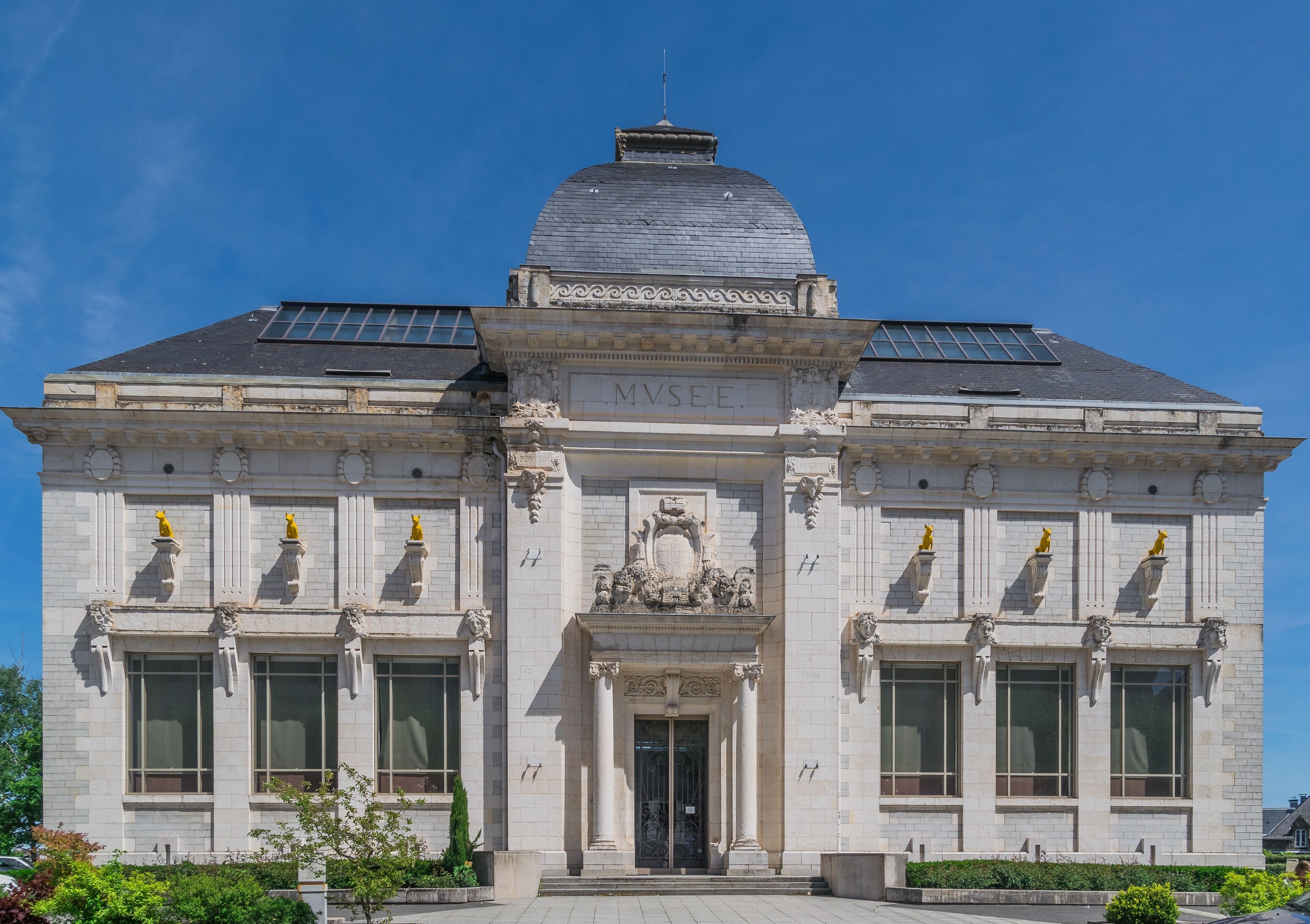 A historic building with a dome, solar panels, and the inscription "MVSER".
