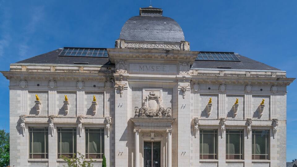 A historic building with a dome, solar panels, and the inscription "MVSER".
