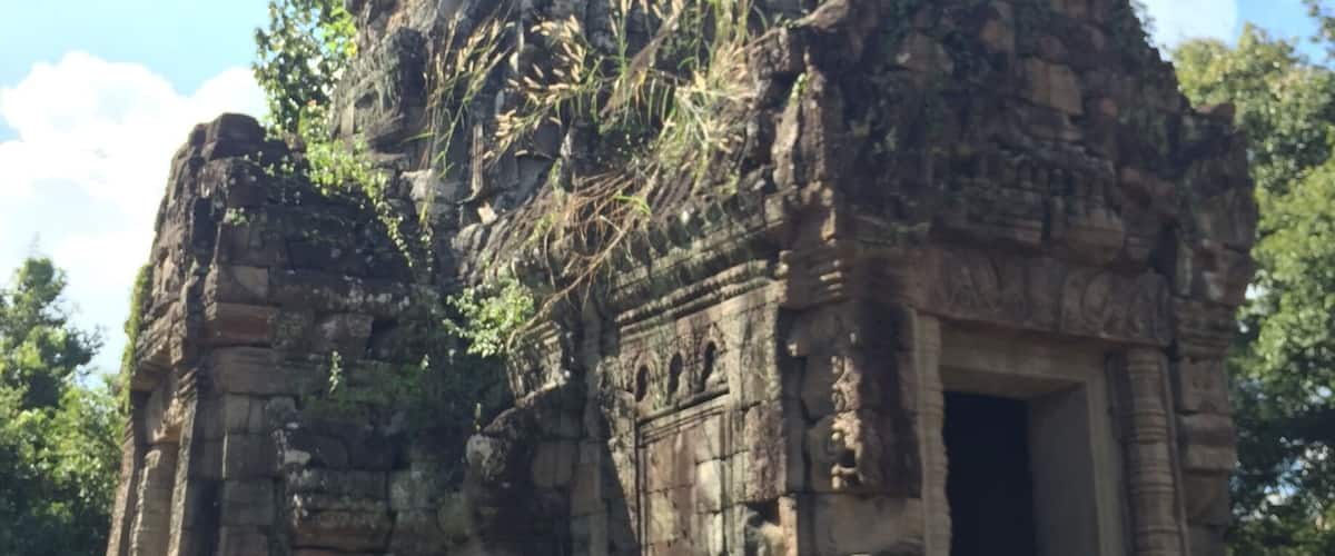 An ancient stone temple with intricate carvings and a large central doorway.