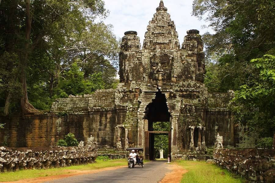 An ancient stone temple entrance surrounded by lush greenery.