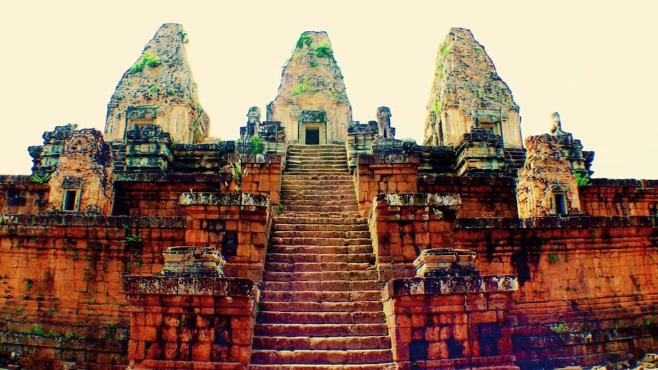 A temple with a central staircase leading to a doorway, flanked by two large towers.