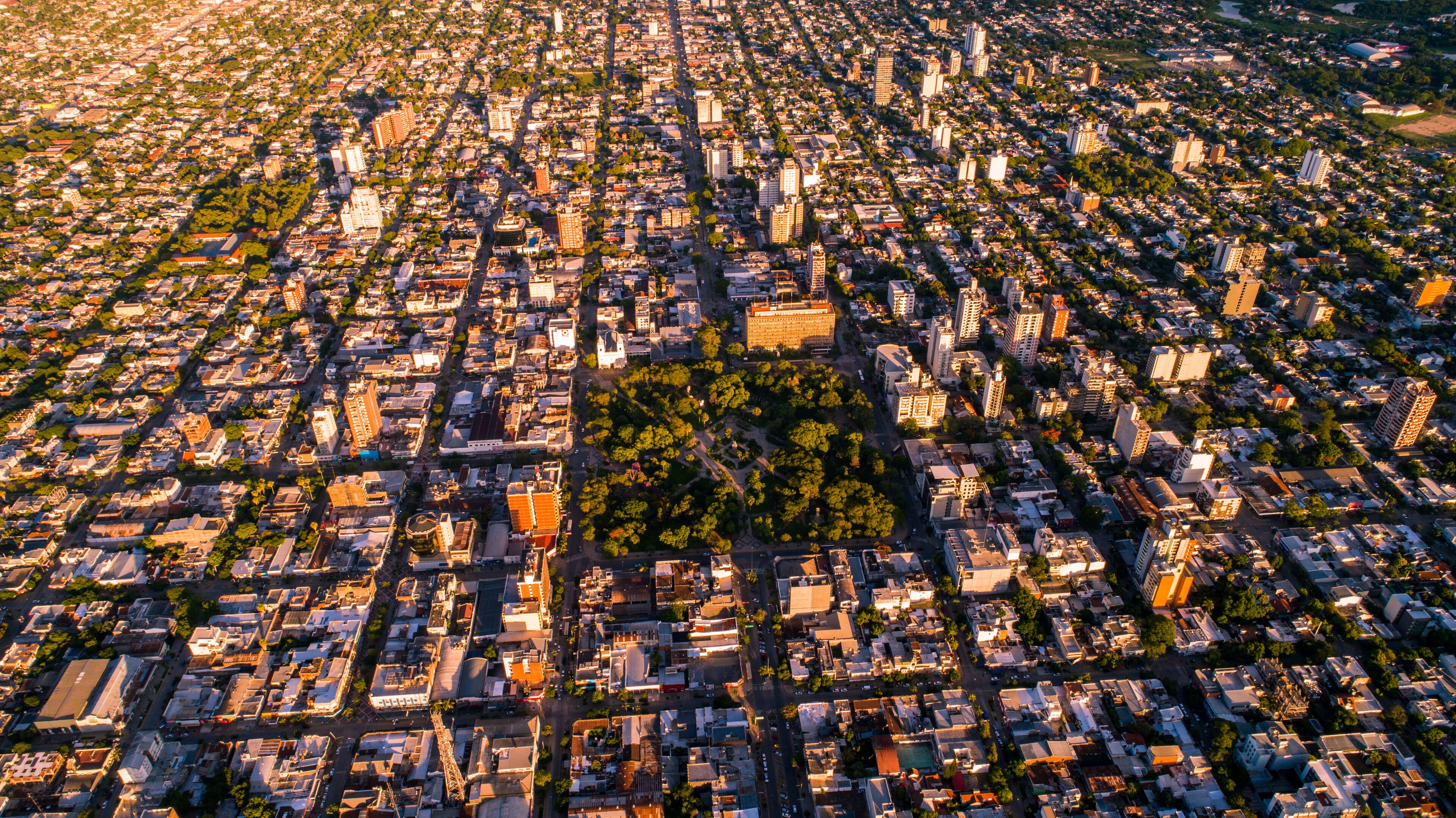 An aerial view of a densely populated city with a central park surrounded by buildings and streets.