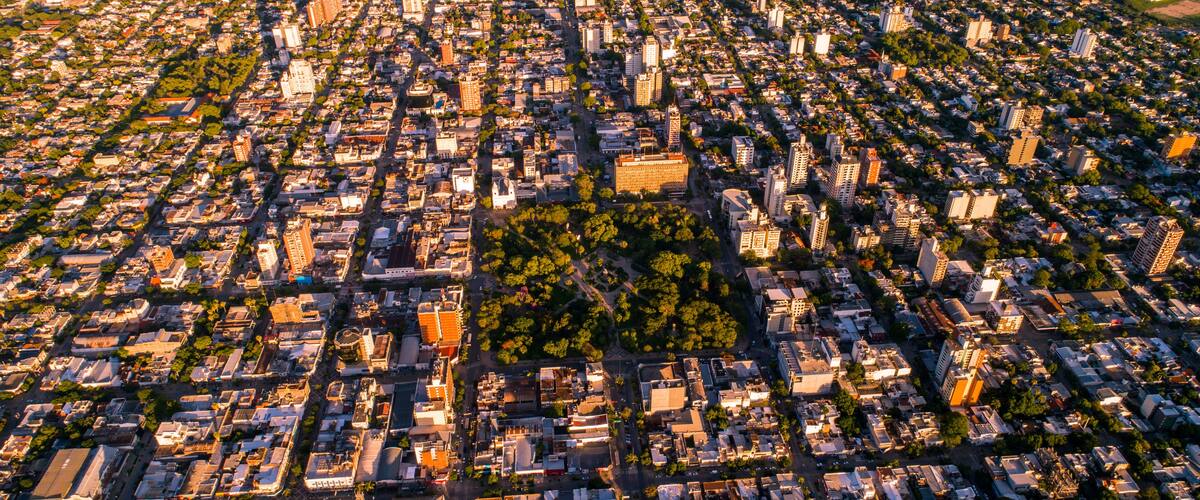 An aerial view of a densely populated city with a central park surrounded by buildings and streets.