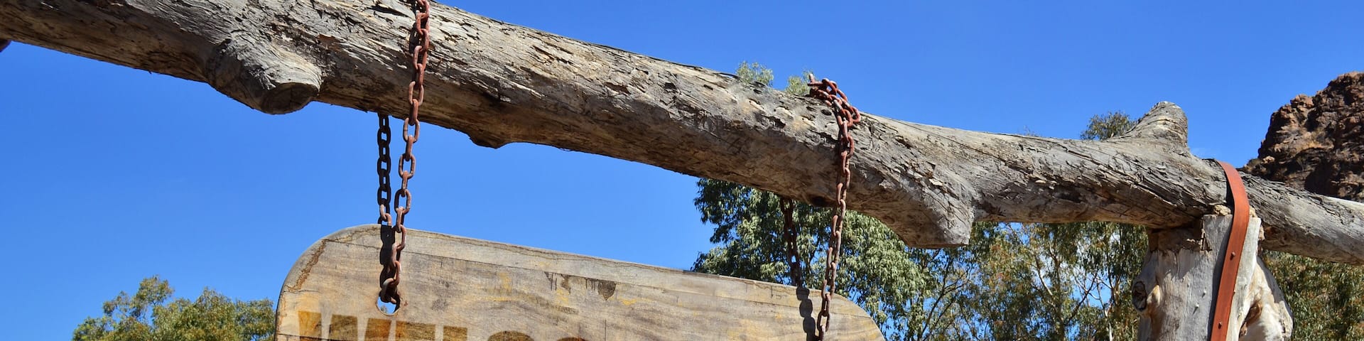 vintage wood signboard with text " welcome to Reynosa" hanging on a branch
