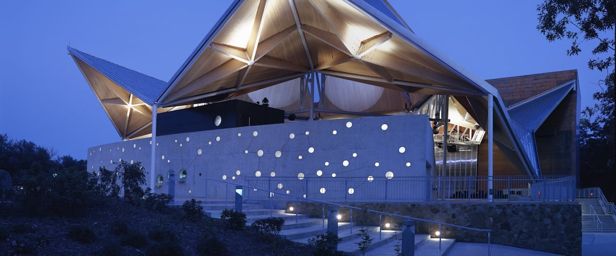 Ein modernes architektonisches Gebäude mit einer dreieckigen Dachkonstruktion und runden Fenstern.