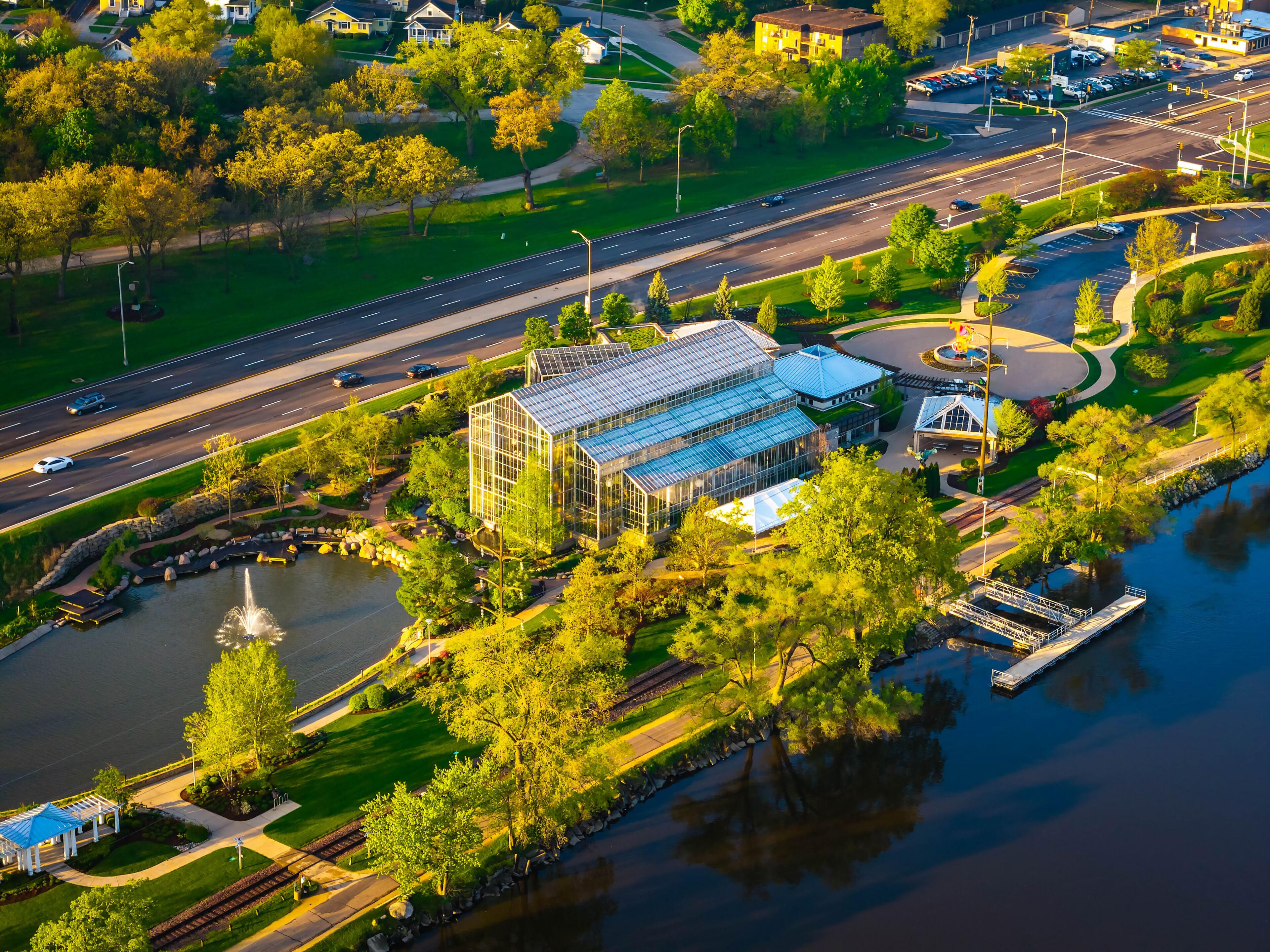 A large glass greenhouse, a river, and a bridge.