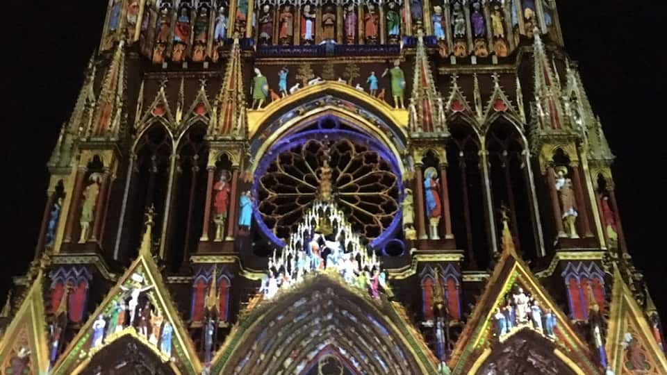 A Gothic cathedral with intricate stained glass windows and a large circular stained glass window at the center.