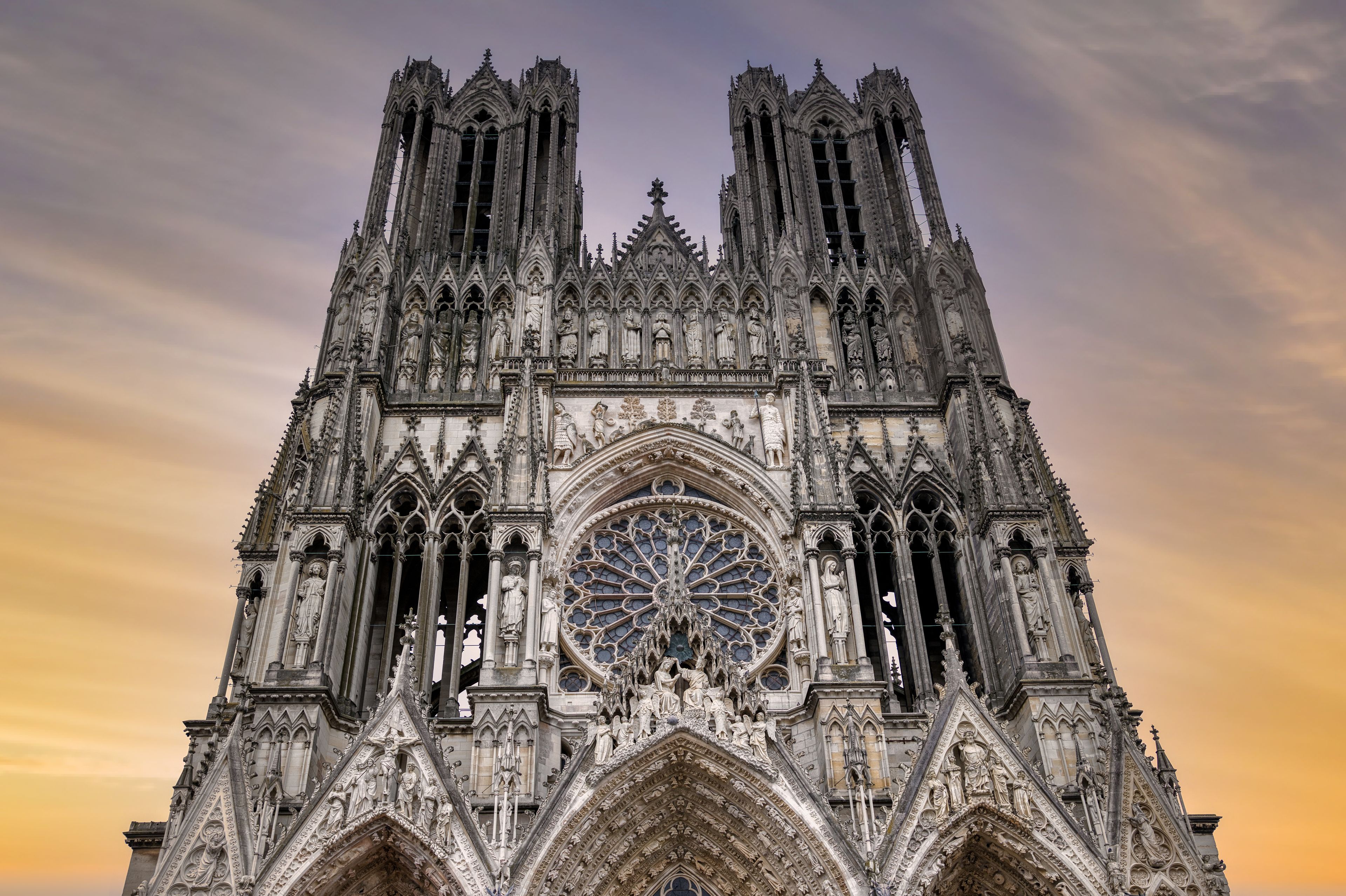 A Gothic cathedral with intricate stone carvings, a large rose window, and two tall spires.