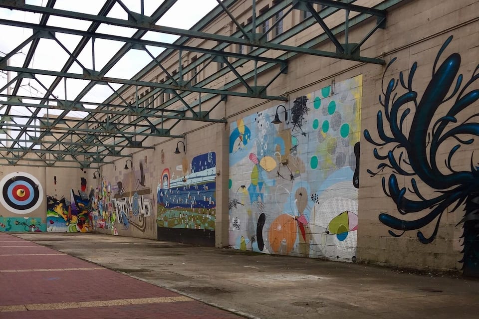 An indoor sports court with colorful graffiti on the walls.