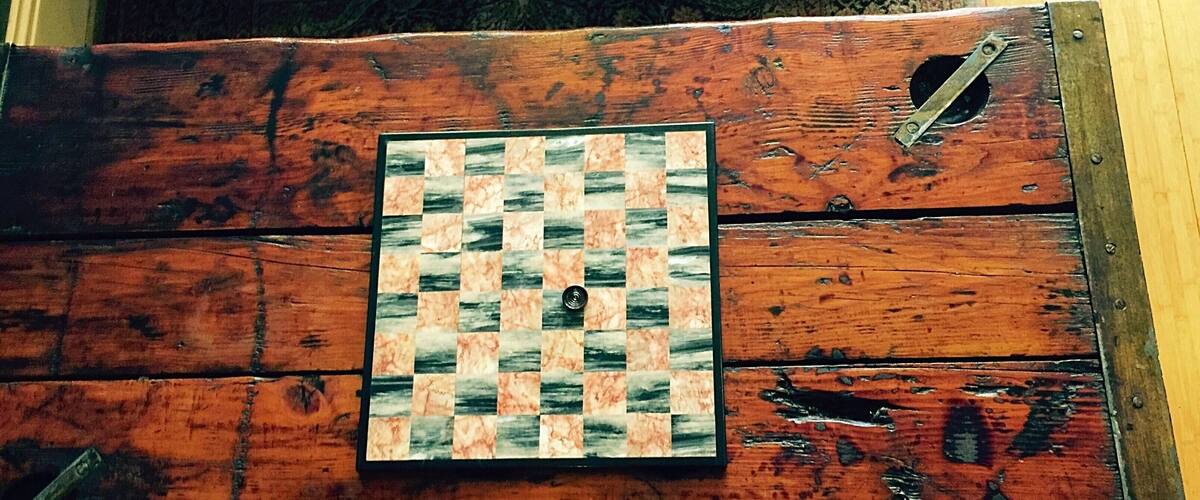 A chessboard on a rustic wooden surface.