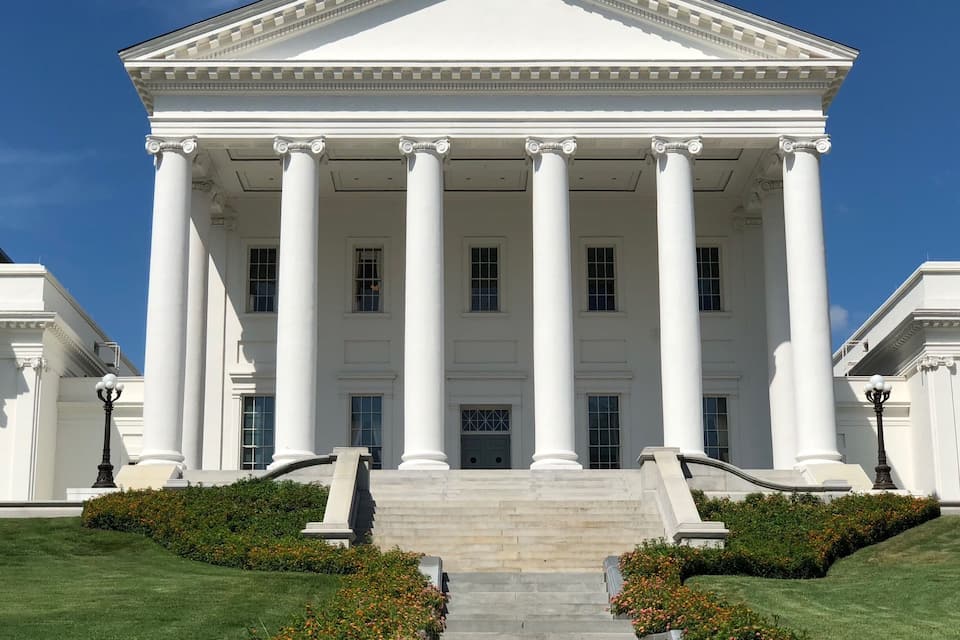 A neoclassical building with a portico supported by columns, a central entrance, and a symmetrical facade.
