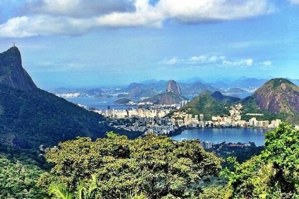 A cityscape with a prominent mountain and a large body of water.