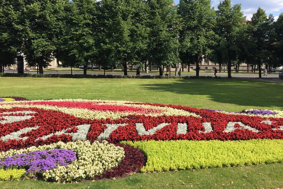Ein Park mit einem großen Blumenbeet, das die Schriftzüge 'SAVANNAH' in rot, weiß und gelb formt.