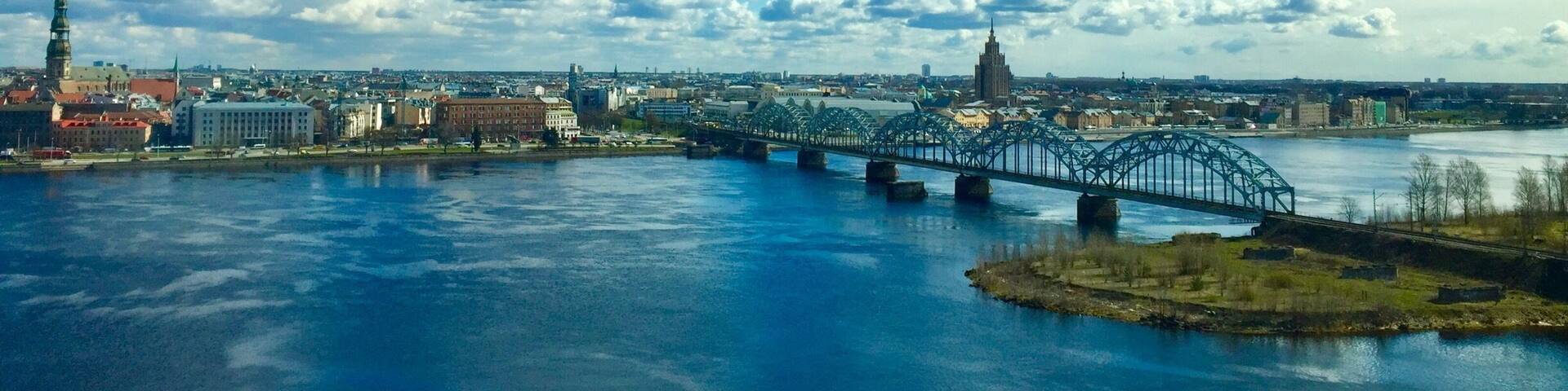 A river with a bridge, a city skyline, and a prominent tower.