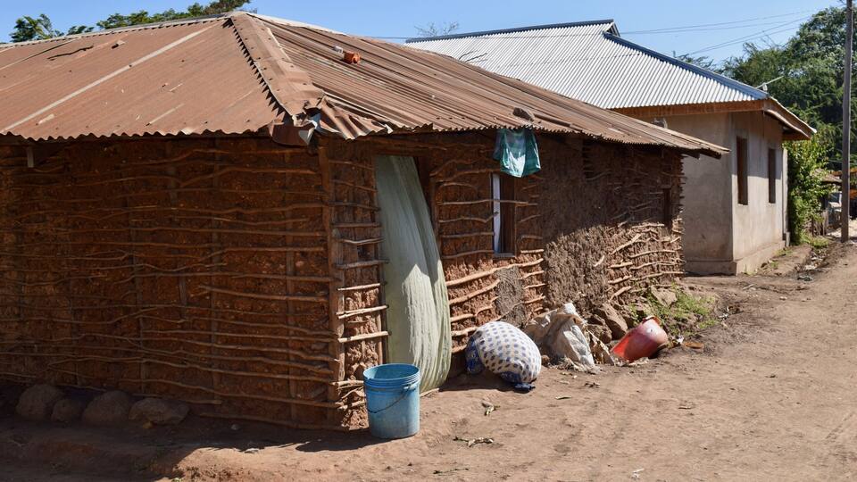 A rustic building with a corrugated metal roof and a brick wall.
