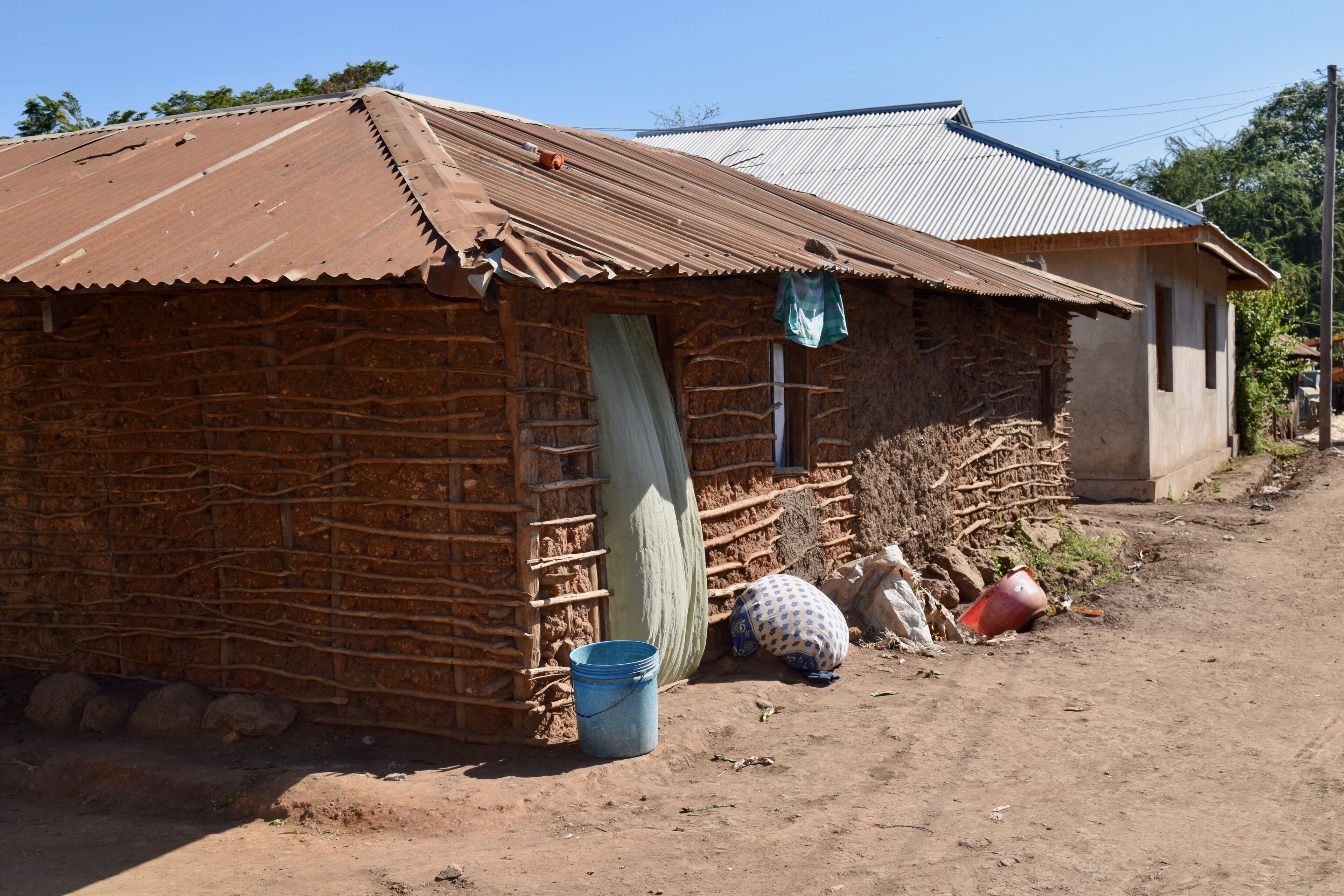 A rustic building with a corrugated metal roof and a brick wall.