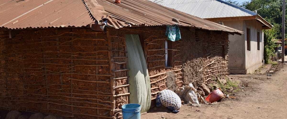 A rustic building with a corrugated metal roof and a brick wall.