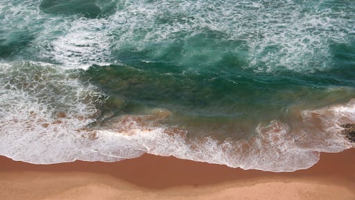 A sandy beach with waves crashing onto the shore.