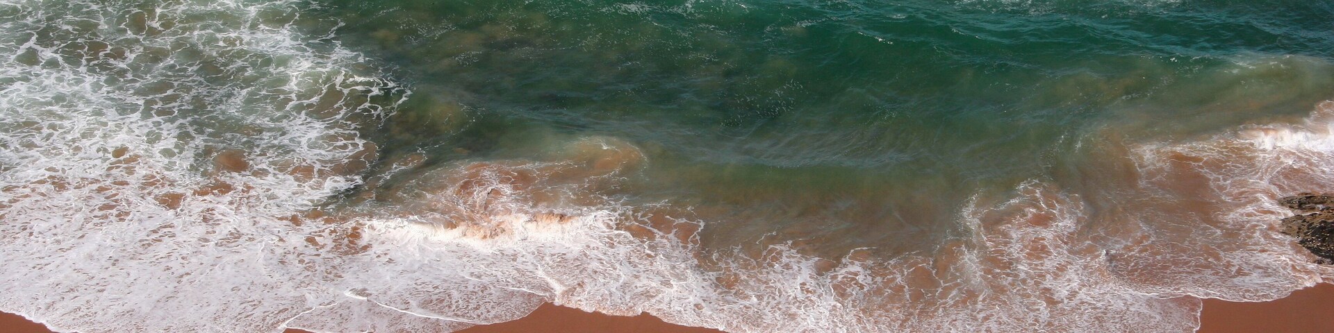 A sandy beach with waves crashing onto the shore.