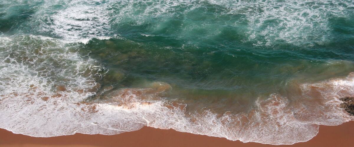 A sandy beach with waves crashing onto the shore.