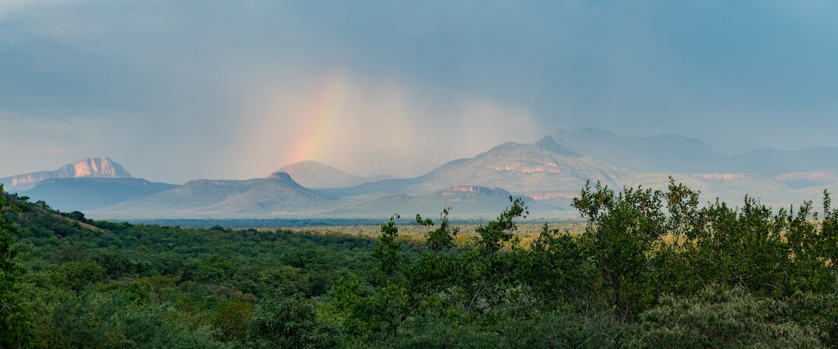 A mountain range with a rainbow in the distance.