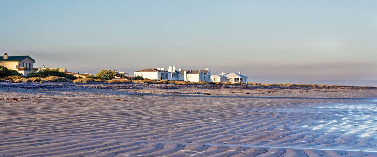 A beach with houses in the background.