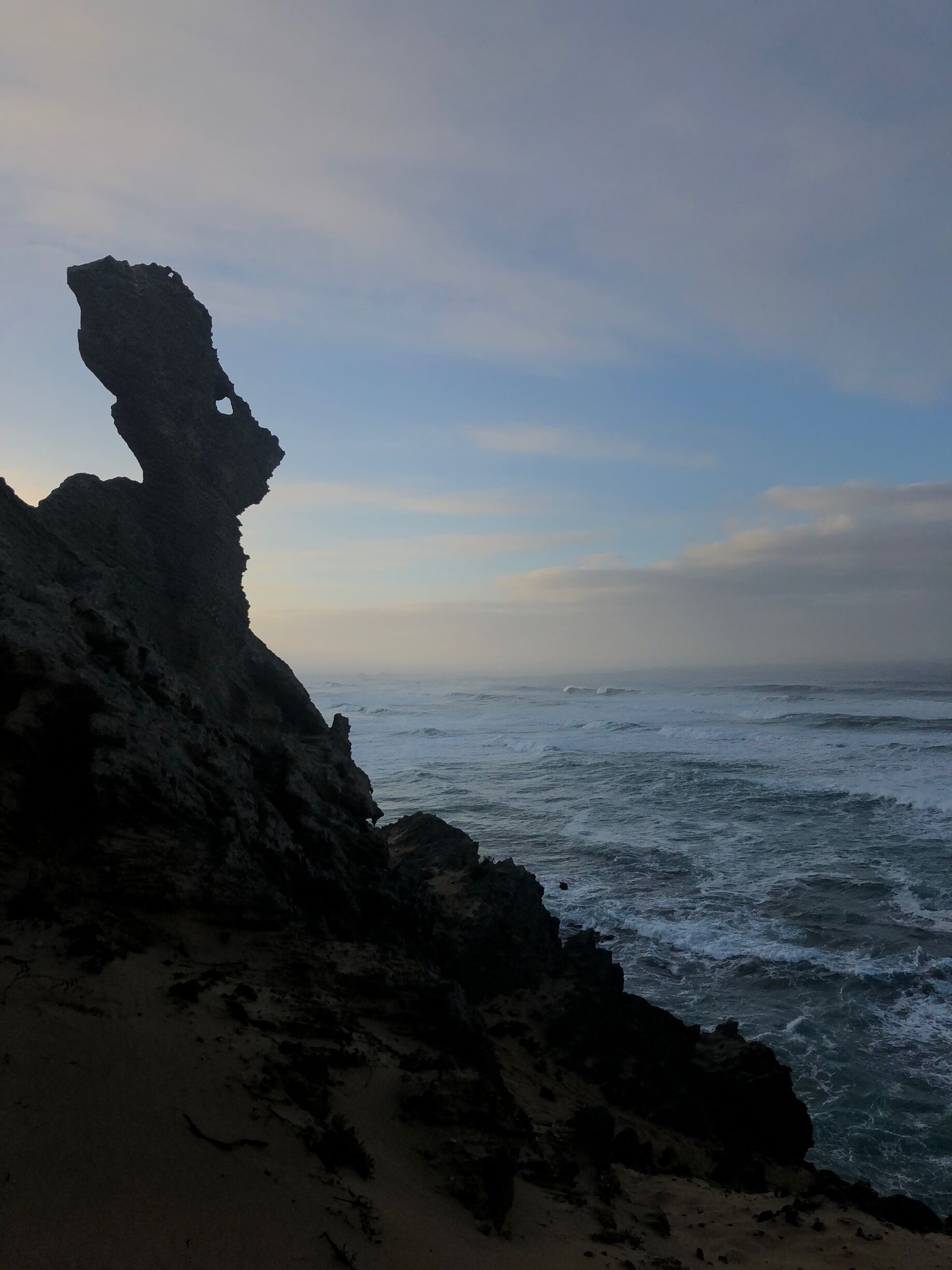 A rocky coastline with a prominent rock formation.