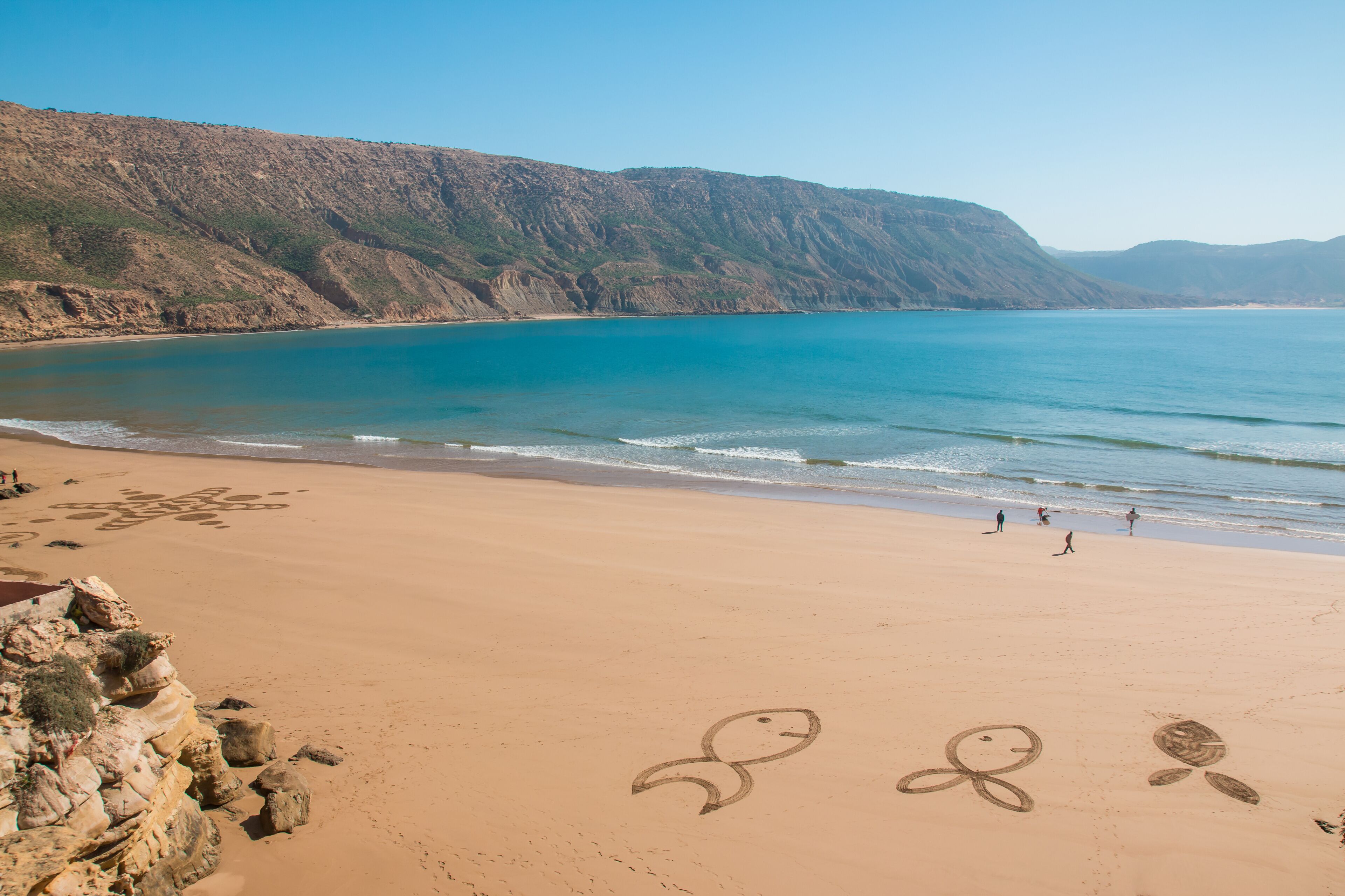 Figures in sand on the beach of Imsouane Morocco