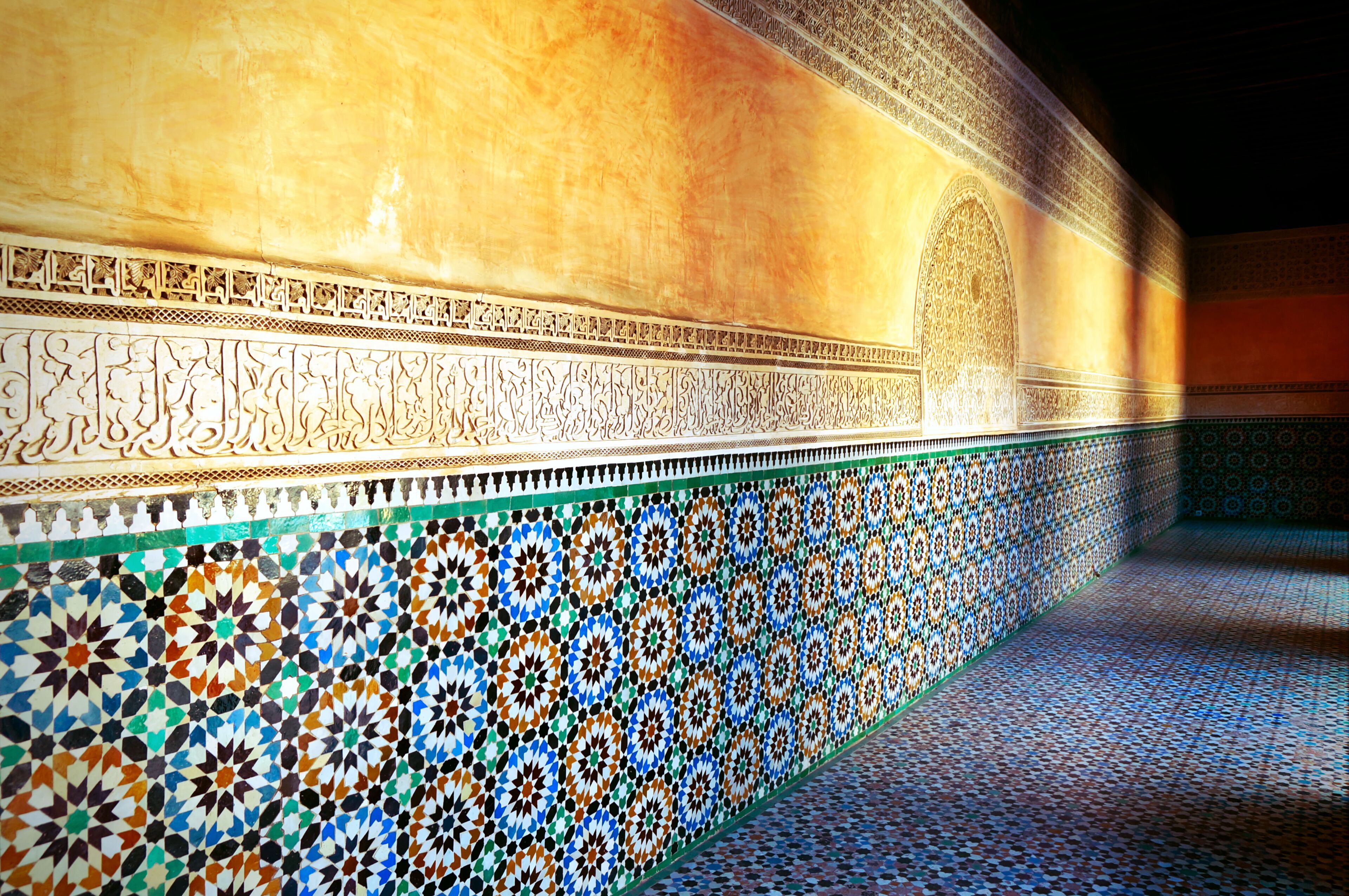 A detailed mosaic wall with geometric patterns and Arabic calligraphy.