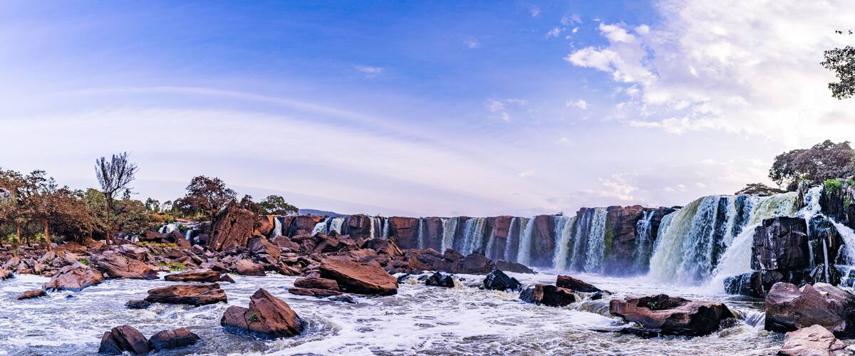 A river with large rocks and a waterfall.