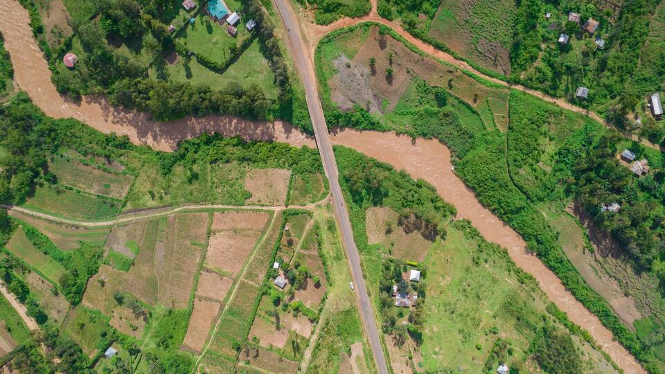 Aerial view of the lush River Yala flowing through tranquil countryside with fields and homes, Sinaga, Gem, Siaya, Kenya.
