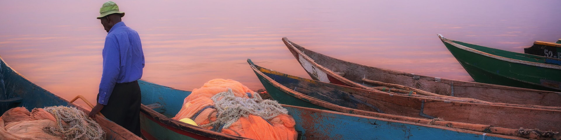 Colorful scenic sunset with fishing boats in the foreground on Mfangano Island, Lake Victoria, Kenya