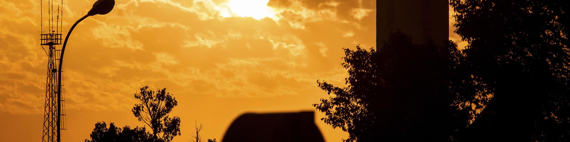 Nairobi, Kenya - 26 August 2014: View of the control tower silhouetted against a fiery sunset, with golden clouds painting the sky above Embakasi.