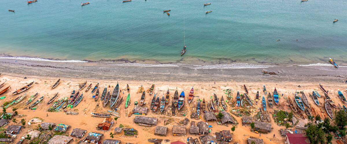 Aerial view of brufut fish market with fishing boats and sandy beach, Banjul, Gambia.