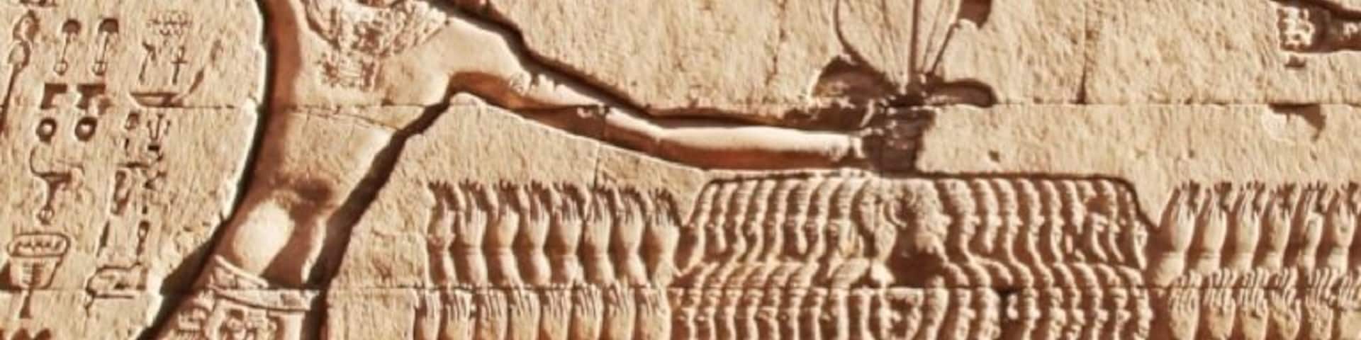 Rameses III smiting his enemies in a single blow. The temple and carvings date from the Greco-Roman period (50-250AD).  This is a great temple to visit on a Nile cruise as the hypostyle hall still has it's ceiling. The ruins sit 30ft (9m) below present-day street level in an excavated pit. Despite its impressive size, only the hypostyle hall has been excavated - the entire temple is about four times larger but still lies buried beneath the streets.